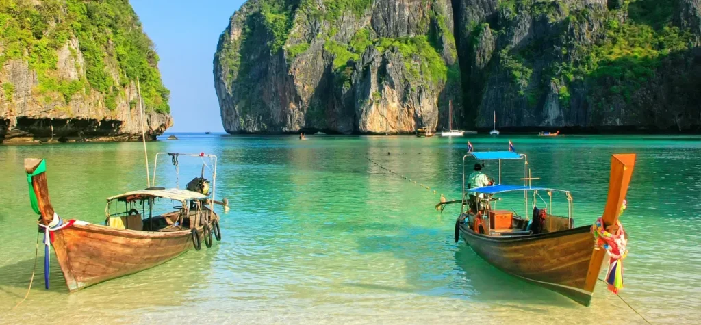 raditional long-tail boat floating in crystal-clear waters of Maya Bay – iconic experience in Thailand travel packages from India