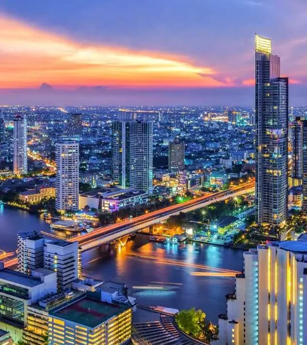 Scenic view of Bangkok city skyline with buildings, lights, and sunset