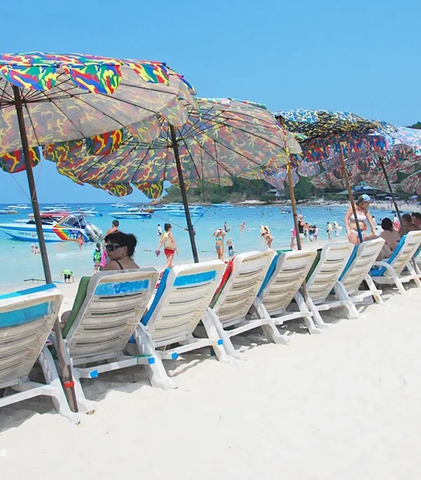 ourists relaxing under umbrellas and enjoying beach views at Coral Island (Koh Larn)
