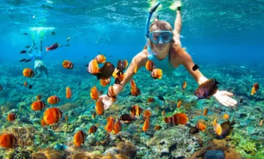 Tourist woman snorkeling underwater at Coral Island Pattaya, exploring marine life