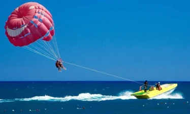 ourist enjoying parasailing adventure over the sea at Coral Island Pattaya