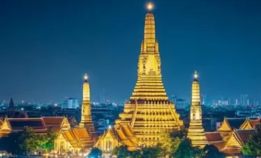 Chao Phraya Dinner Cruise at night with illuminated Wat Arun in the background