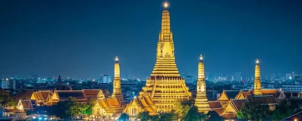 Chao Phraya Dinner Cruise at night with illuminated Wat Arun in the background