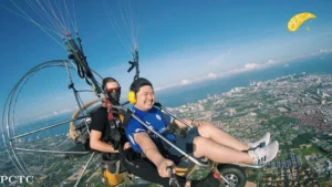 Paramotor flying over the coastline of Pattaya during sunrise