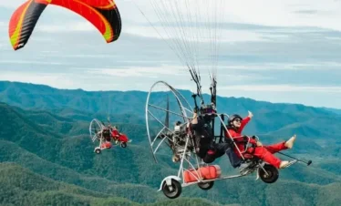 Tourist taking off with a pilot on a tandem paramotor ride in Pattaya