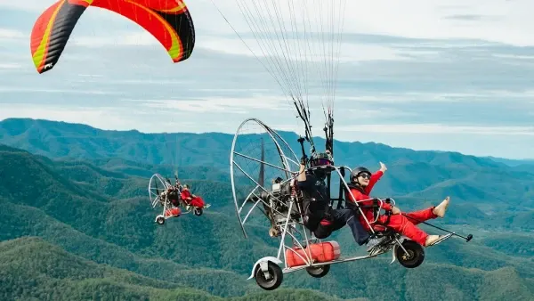 Tourist taking off with a pilot on a tandem paramotor ride in Pattaya