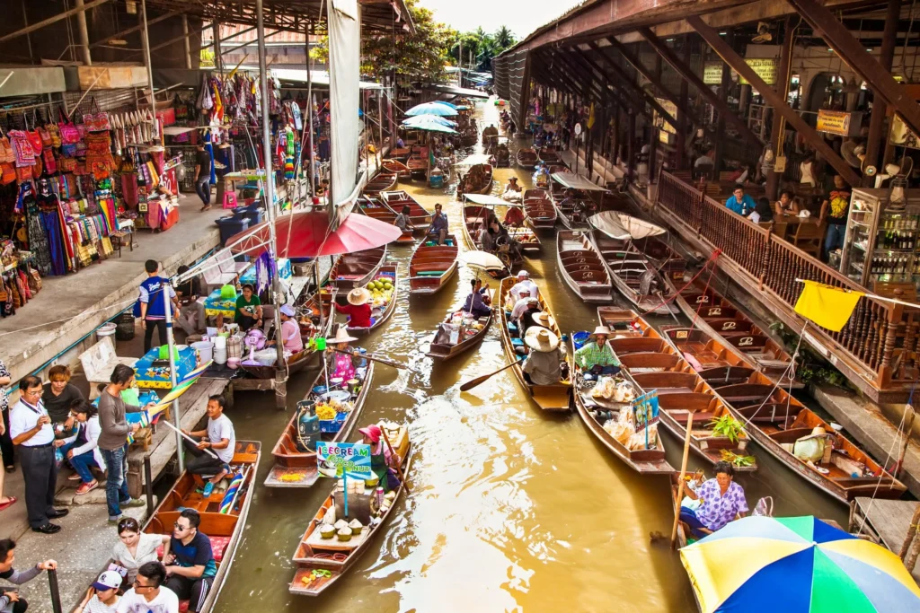 Vibrant boats filled with tropical fruits and local food at Damnoen Saduak Floating Market