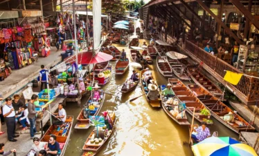 Vibrant boats filled with tropical fruits and local food at Damnoen Saduak Floating Market