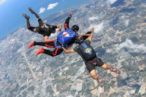 Three people skydiving in free-fall above Pattaya with stunning aerial view