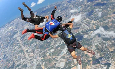 Three people skydiving in free-fall above Pattaya with stunning aerial view
