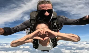 Skydiving passenger and instructor posing mid-air during free-fall over Pattaya