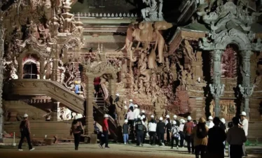 Tourist exploring the wooden sculptures at The Sanctuary of Truth