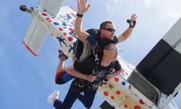 Tandem skydiving jump with instructor and passenger exiting the plane over Pattaya