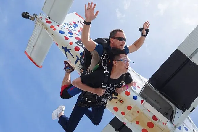Tandem skydiving jump with instructor and passenger exiting the plane over Pattaya