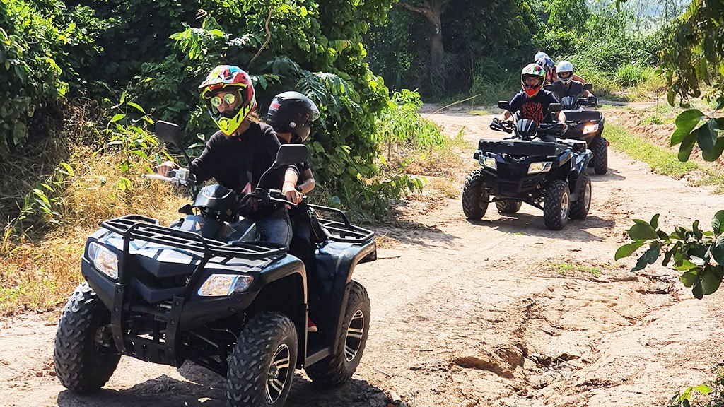 Group of tourists riding ATVs through off-road trails in Pattaya