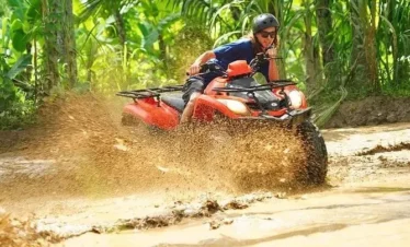 Close-up of ATV tire splashing through muddy terrain