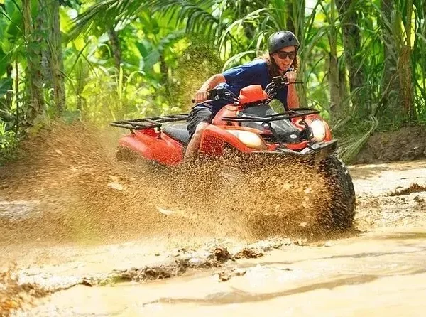Close-up of ATV tire splashing through muddy terrain