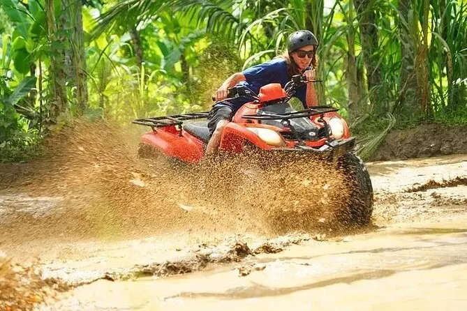 Close-up of ATV tire splashing through muddy terrain