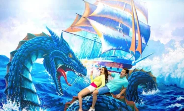 Couple sitting on 3D dragon illusion at Trickeye Museum Phuket