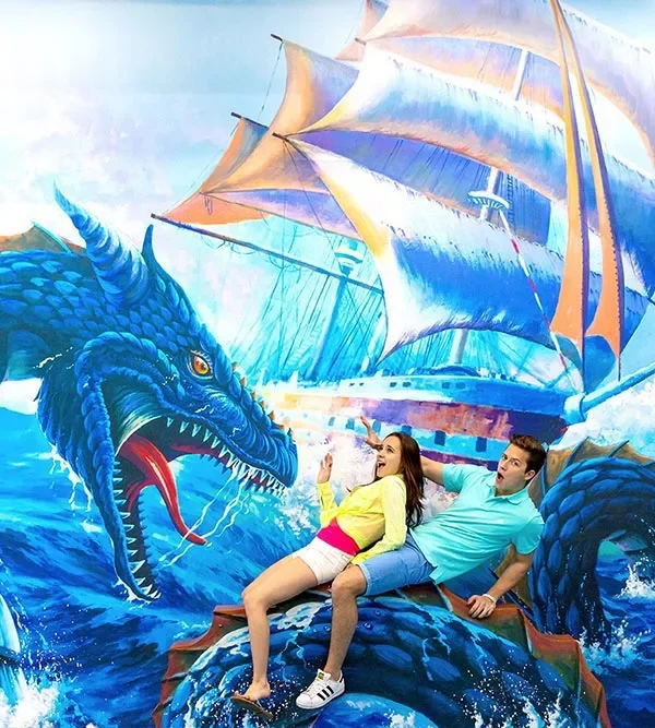 Couple sitting on 3D dragon illusion at Trickeye Museum Phuket