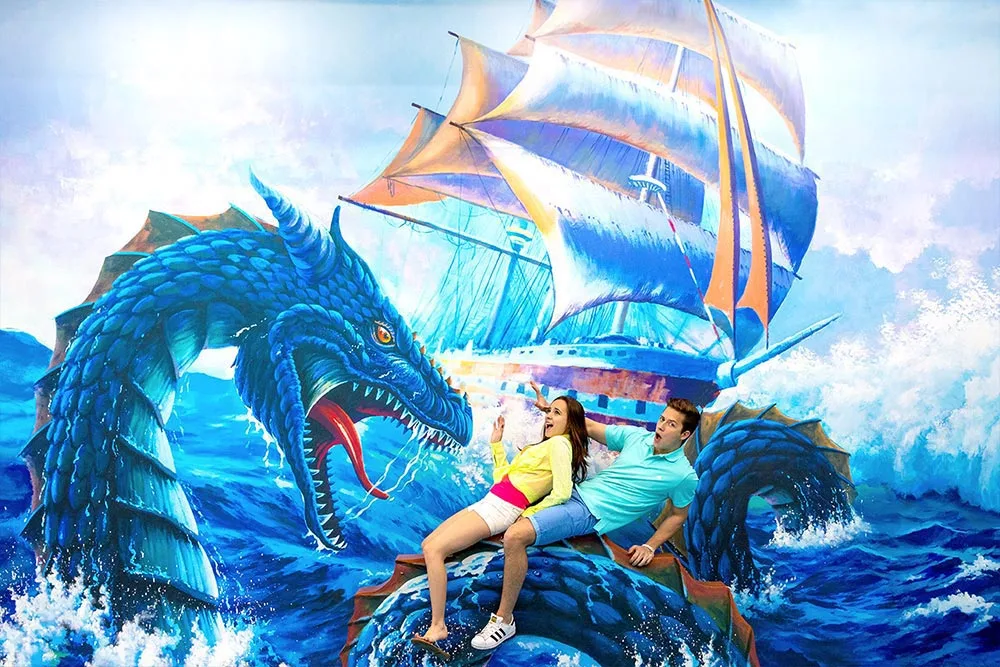 Couple sitting on 3D dragon illusion at Trickeye Museum Phuket