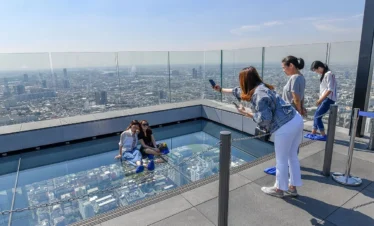 Visitors enjoying the thrilling glass tray experience at Mahanakhon Skywalk