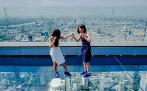 Visitors enjoying the thrilling glass tray experience at Mahanakhon Skywalk