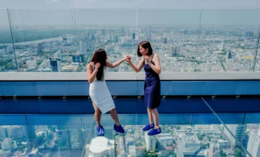 Visitors enjoying the thrilling glass tray experience at Mahanakhon Skywalk
