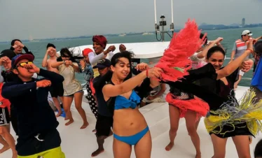 Tourists Dancing and Enjoying Scenic Ocean Views from Yacht in Pattaya