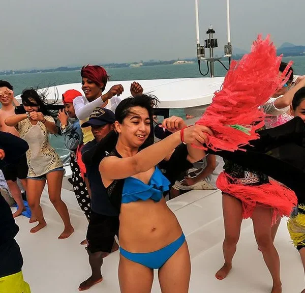 Tourists Dancing and Enjoying Scenic Ocean Views from Yacht in Pattaya