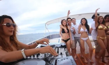 DJ playing music and women dancing during Pattaya yacht party