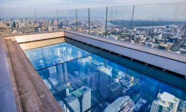 Tourist walking over the glass tray at the Mahanakhon Skywalk, 314 meters above ground