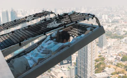 Traveler enjoying the Mahanakhon I‑Tilt ride with panoramic view of Bangkok at sunset