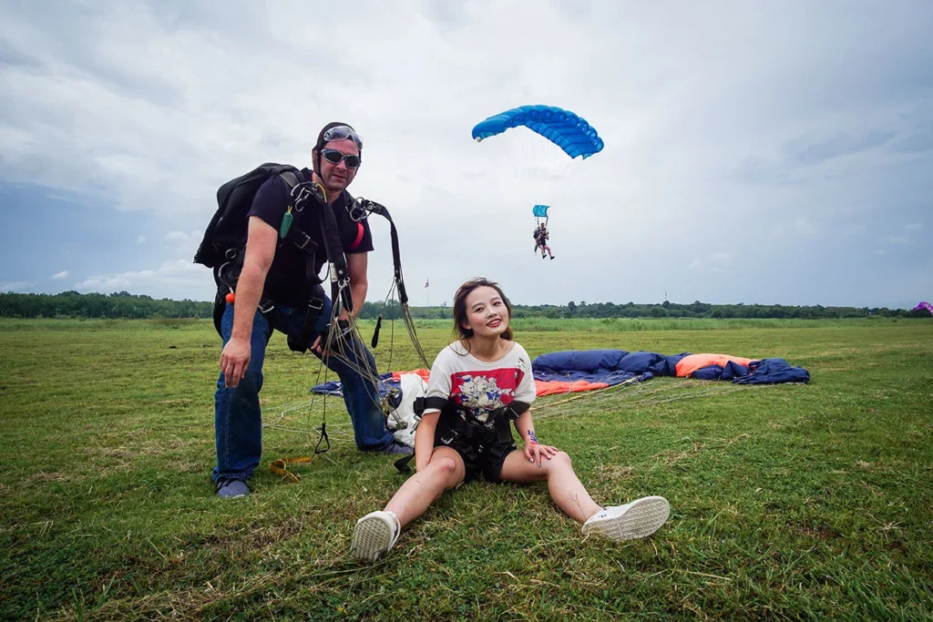 Tandem skydiver and instructor posing after landing in Khao Yai.