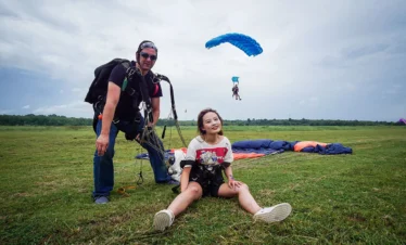 Tandem skydiver and instructor posing after landing in Khao Yai.