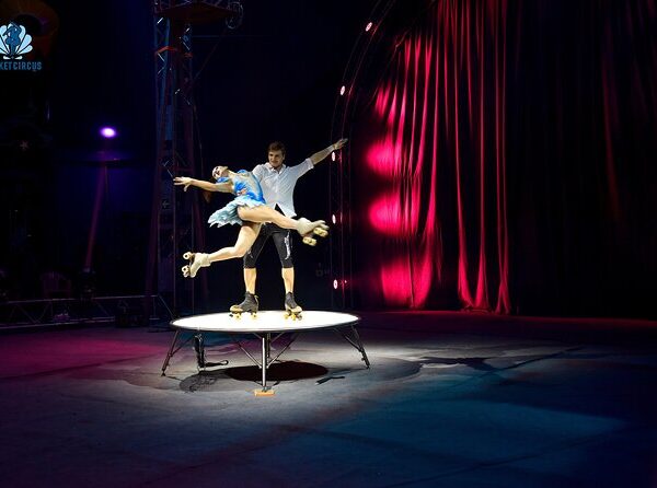 Aerial silk performer performing high above stage at Phuket Circus with dramatic lighting